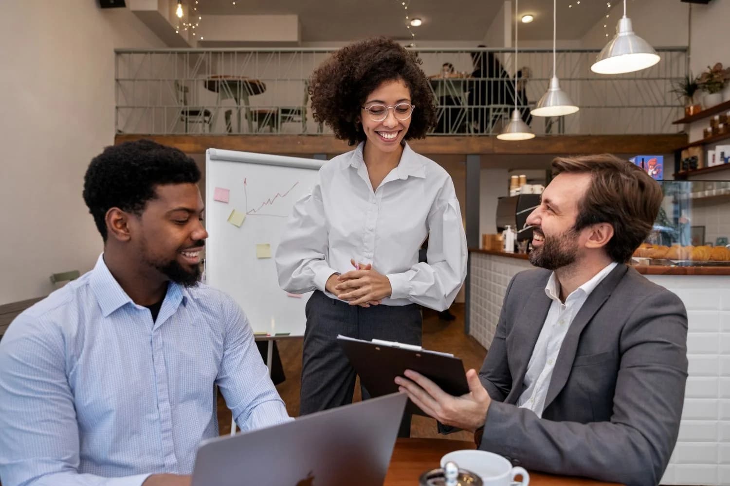 Colleagues discussing a project around a table in a bright office